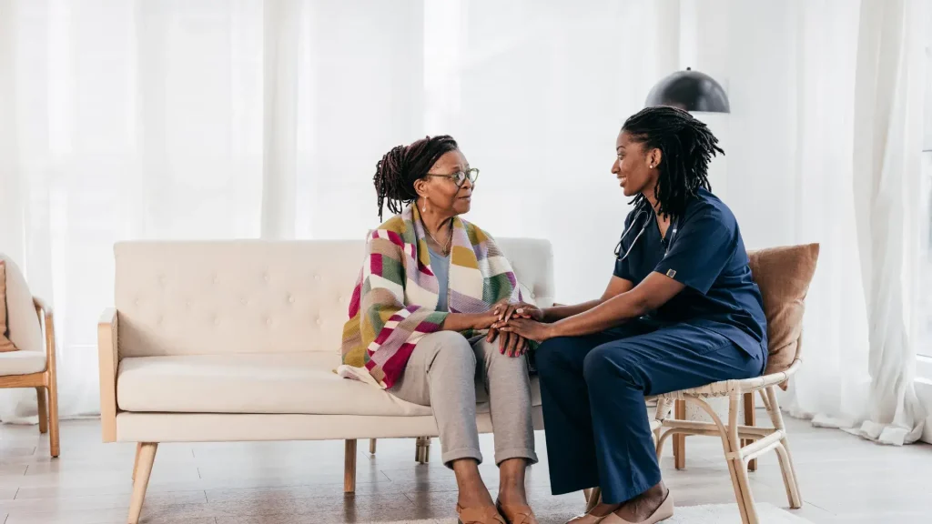 Nurse smiling with elderly patient in room